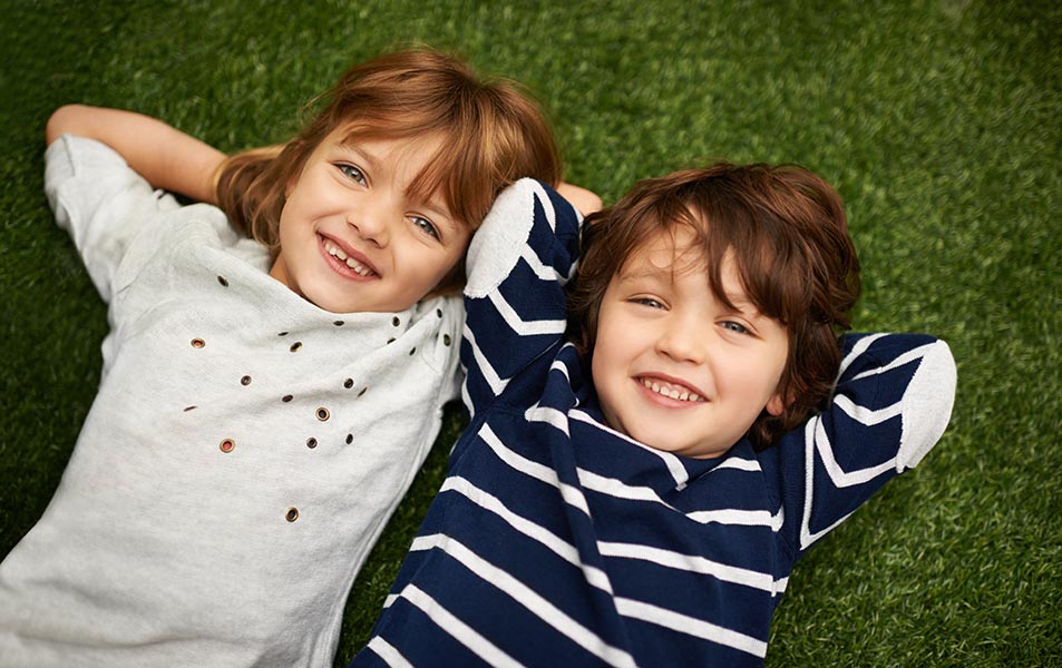 Hanging out with my sibling. Brother and sister relaxing on the grass in the backyard